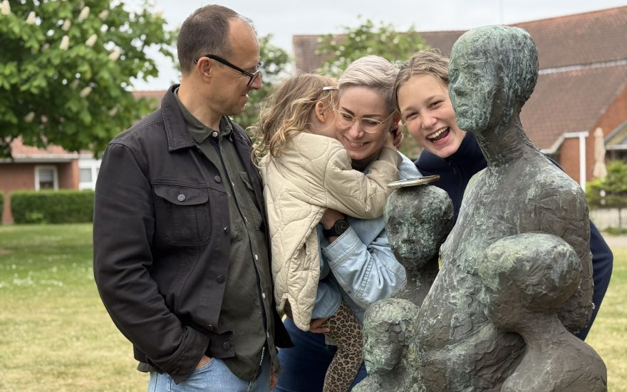 Familien Bøgeblad bliver klogere på Hanne Warmings skulptur 'Mor med børn'.